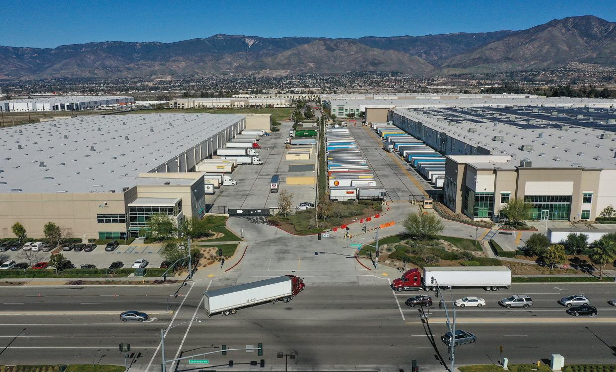 Semi-tractor trailers enter an Amazon fulfillment center, right, and a Munchkin warehouse on San Bernardino Ave. in Redlands, Calif., Wednesday, January 26, 2020.