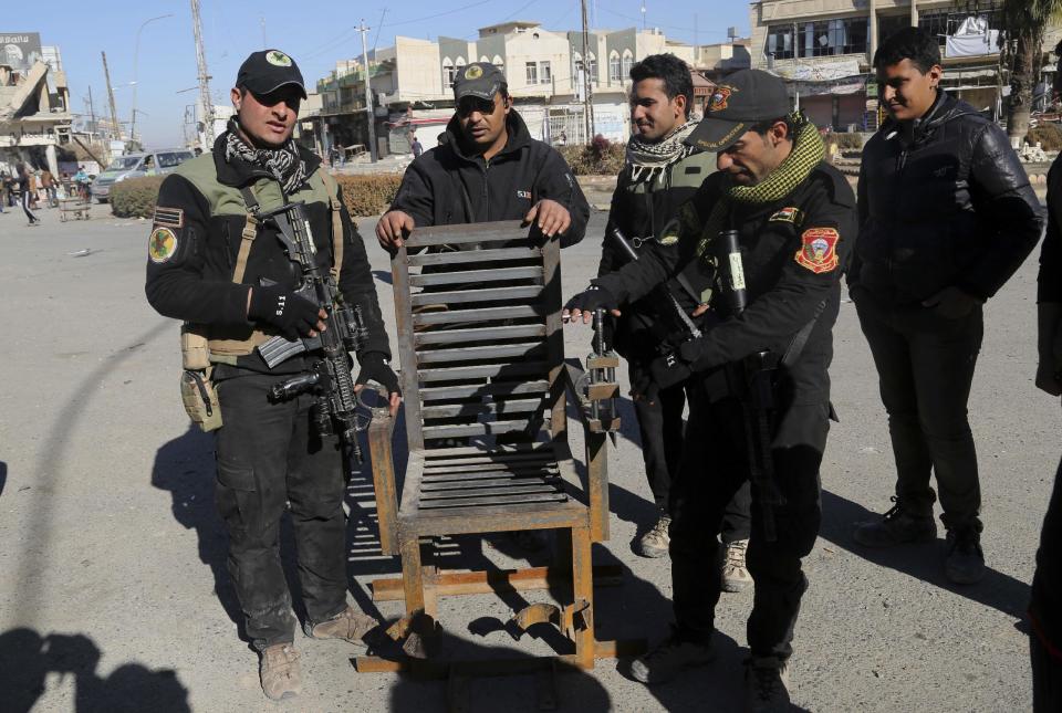 Iraqi special forces forces display a chair they say Islamic State militants used to torture people, found in a detention facility in a neighborhood recently liberated from IS in Mosul, Iraq, Thursday, Jan. 12, 2017. (AP Photo/Khalid Mohammed)