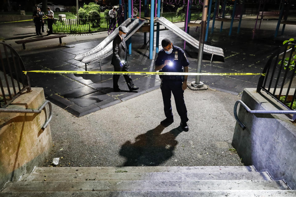 Police officers search a playground for evidence at a crime scene where two individuals were injured by gunshots on Atlantic Avenue, Saturday, July 18, 2020, in the Brooklyn borough of New York. President Donald Trump is again threatening to send federal agents to New York City if local authorities don't stop a surge of violence that has left seven people dead and more than 50 people shot since Friday, Aug. 14. (AP Photo/John Minchillo, File)