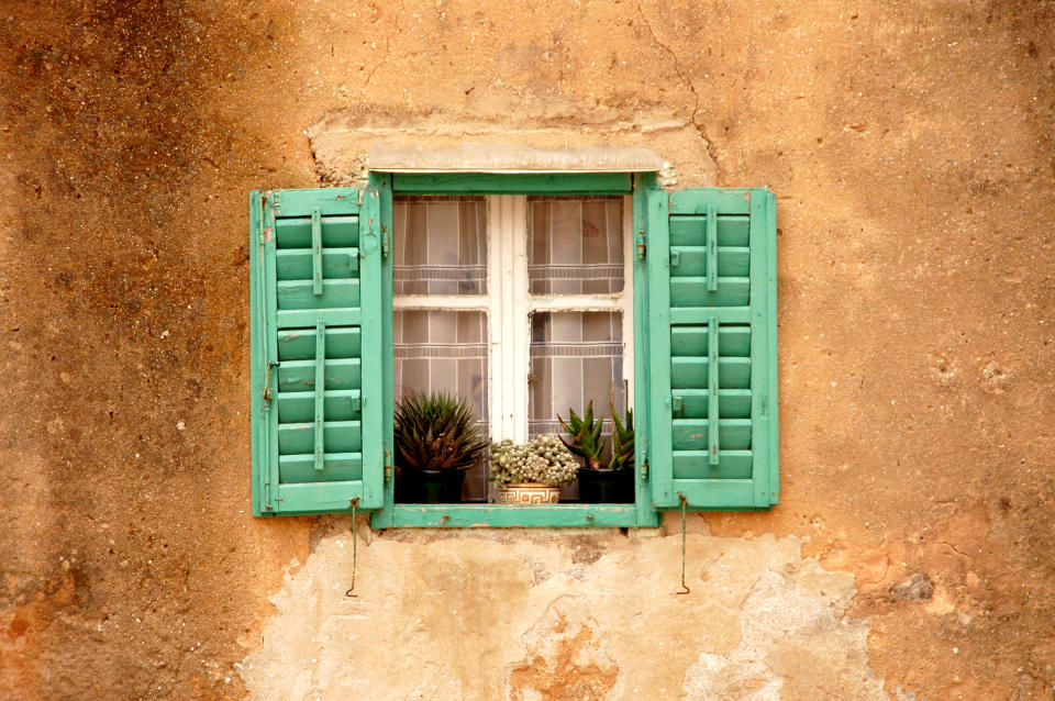 an old house window decorated with flowers