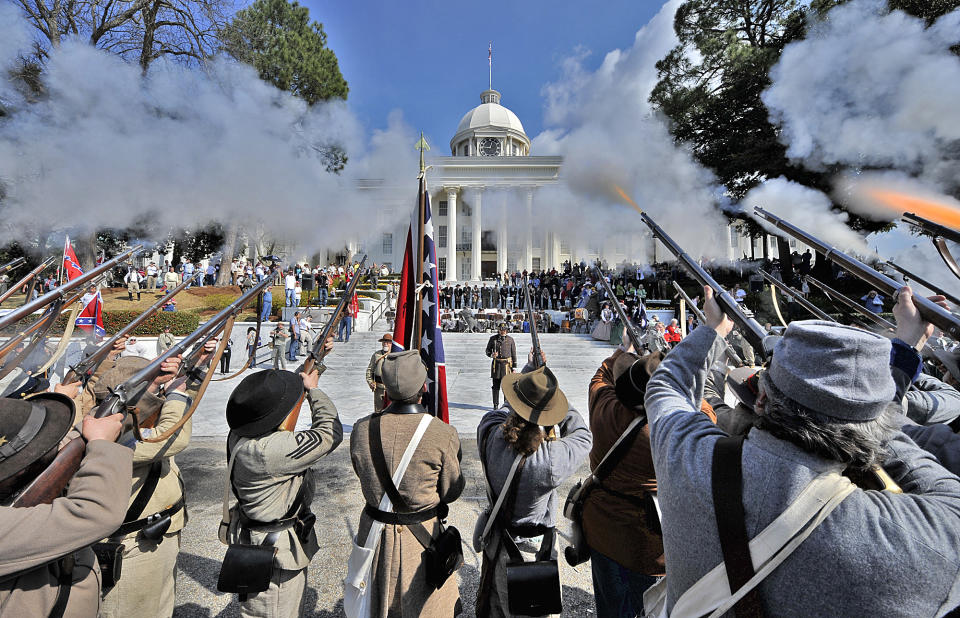 FILE - Members of the Sons of Confederate Veterans fire their rifles in celebration in Montgomery, Ala. on Saturday, Feb. 19, 2011 following the re-enactment of the 1861 swearing-in ceremony of Confederate States of America provisional President Jefferson Davis on the steps of the Alabama State Capitol. (AP Photo/Kevin Glackmeyer, File)