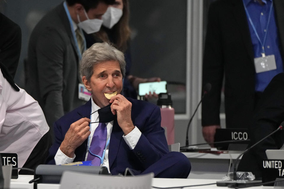 John Kerry, United States Special Presidential Envoy for Climate sits down to eat a snack during a stocktaking plenary session at the COP26 U.N. Climate Summit in Glasgow, Scotland, Saturday, Nov. 13, 2021. Going into overtime, negotiators at U.N. climate talks in Glasgow are still trying to find common ground on phasing out coal, when nations need to update their emission-cutting pledges and, especially, on money. (AP Photo/Alastair Grant)