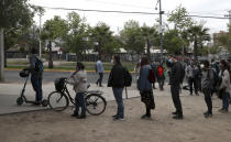 People line up for their turn to vote during a referendum to decide whether the country should replace its 40-year-old constitution, in Santiago, Chile, Sunday, Oct. 25, 2020.(AP Photo/Esteban Felix)