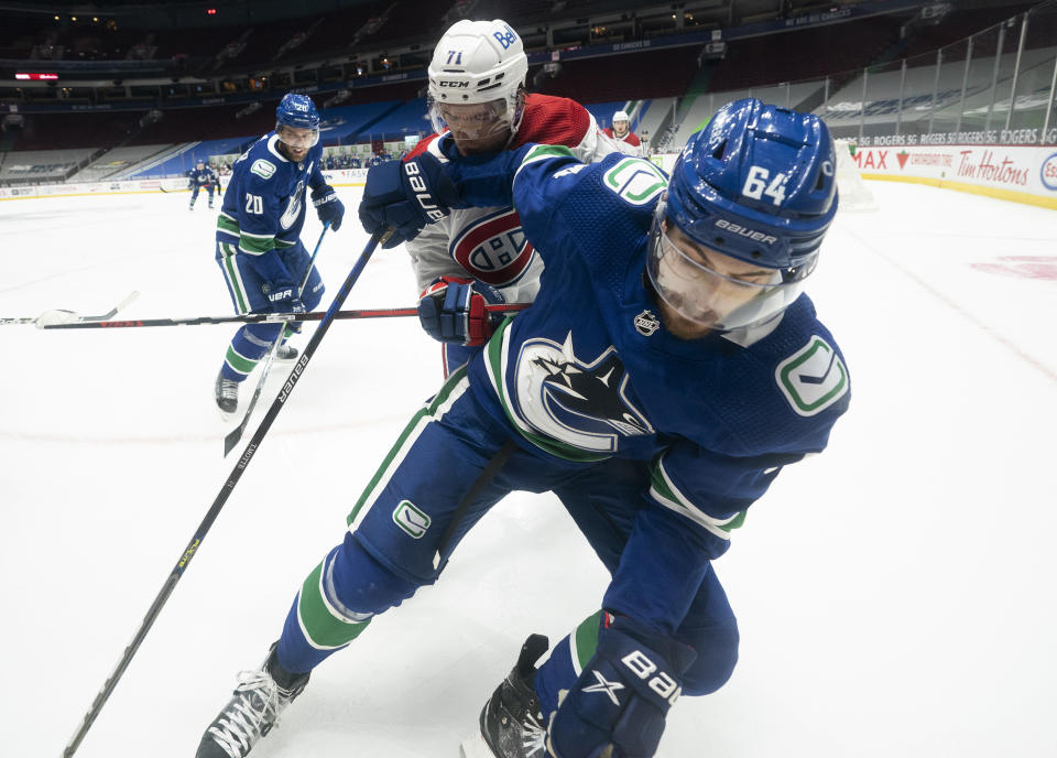 Vancouver Canucks center Tyler Motte (64) vies for control of the puck with Montreal Canadiens center Jake Evans (71) during the second period of an NHL hockey game Wednesday, Jan. 20, 2021, in Vancouver, British Columbia. (Jonathan Hayward/The Canadian Press via AP)