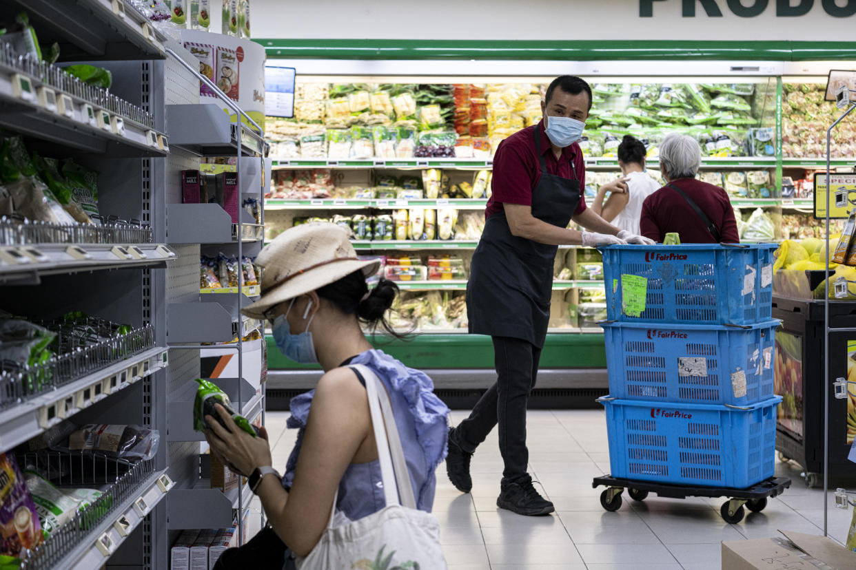 SINGAPORE, SINGAPORE - APRIL 6: People wearing protective masks shop in a supermarket on April 6, 2020 in Singapore, a day before a 'circuit breaker' takes effect. The Singapore government will close all schools and most workplaces and limit social interactions and movement outside homes for at least a month to stem the spike in local coronavirus cases. (Photo by Ore Huiying/Getty Images)