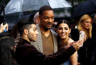 <p>Mena Massoud (Aladdín) no dudó en sacar su móvil para hacerse un <em>selfie</em> con Will Smith (Genio) y Naomi Scott (Jasmín). (Foto: Henry Nicholls / Reuters). </p>