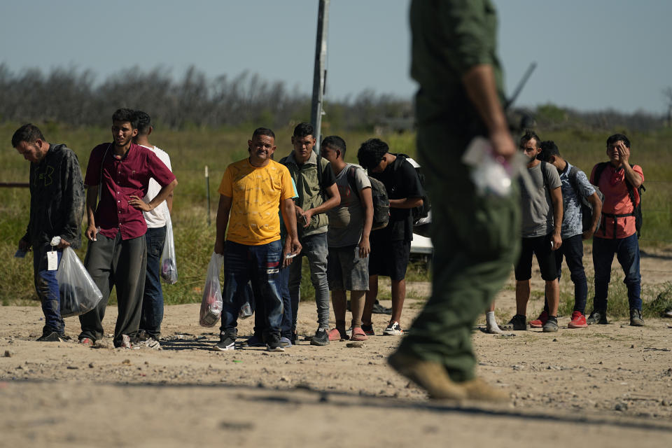 Migrants wait to be processed by the U.S. Customs and Border Patrol after they crossed the Rio Grande and entered the U.S. from Mexico, Thursday, Oct. 19, 2023, in Eagle Pass, Texas. Starting in March, Texas will give police even broader power to arrest migrants while also allowing local judges to order them out of the U.S. under a new law signed by Republican Gov. Greg Abbott. (AP Photo/Eric Gay)