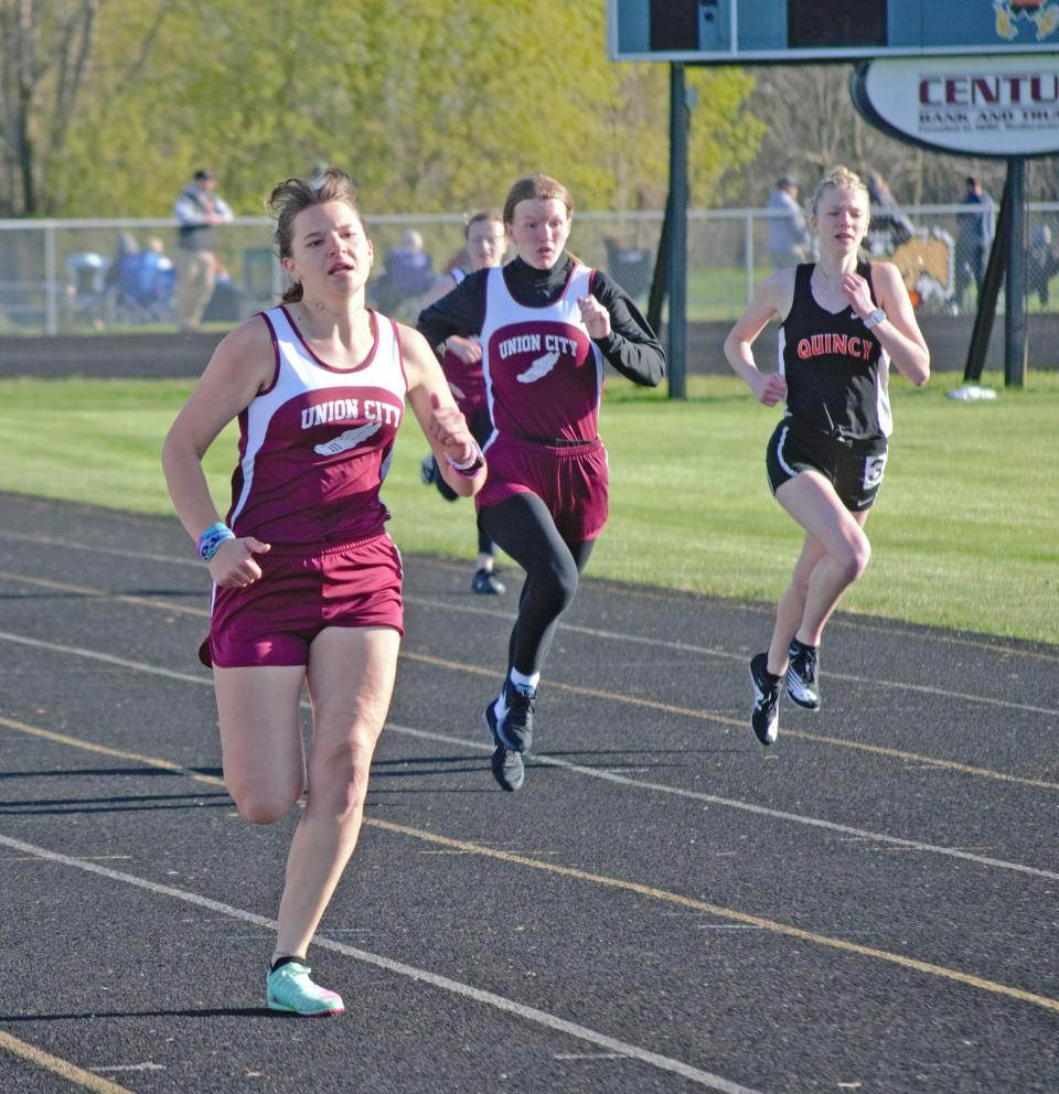 Union City's Kyla Burdick (far left) and Willow Austin (middle) race Quincy's Elizabeth Craig down the back stretch of the 400 meter dash on Wednesday