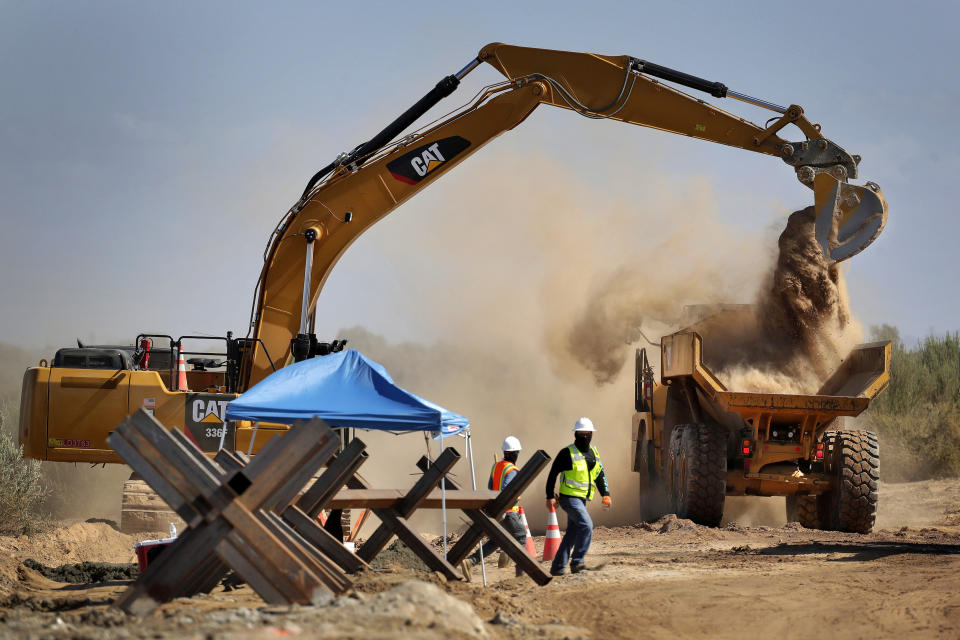 ARCHIVO - En esta fotografía del 10 de septiembre de 2019, unos trabajadores retiran unas barreras que fueron colocadas para separar a México de Estados Unidos, en Yuma, Arizona. (AP Foto/Matt York, Archivo)