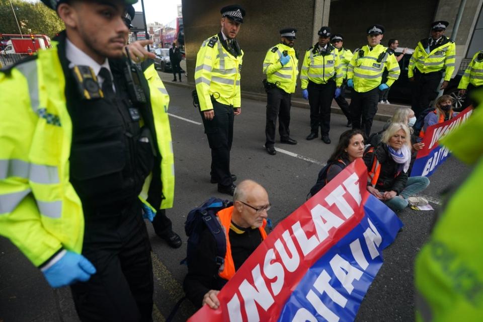 Protesters from Insulate Britain blocking a road near Canary Wharf in east London. Climate group Insulate Britain had pledged to restart its road-blocking protests despite the risk of its members being jailed or fined. Picture date: Monday October 25, 2021. (PA Wire)