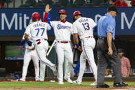 Texas Rangers' Andy Ibáñez (77) is congratulated by teammates after hitting a home run during the first inning of a baseball game against the Oakland Athletics, Monday, June 21, 2021, in Arlington, Texas. (AP Photo/Sam Hodde)