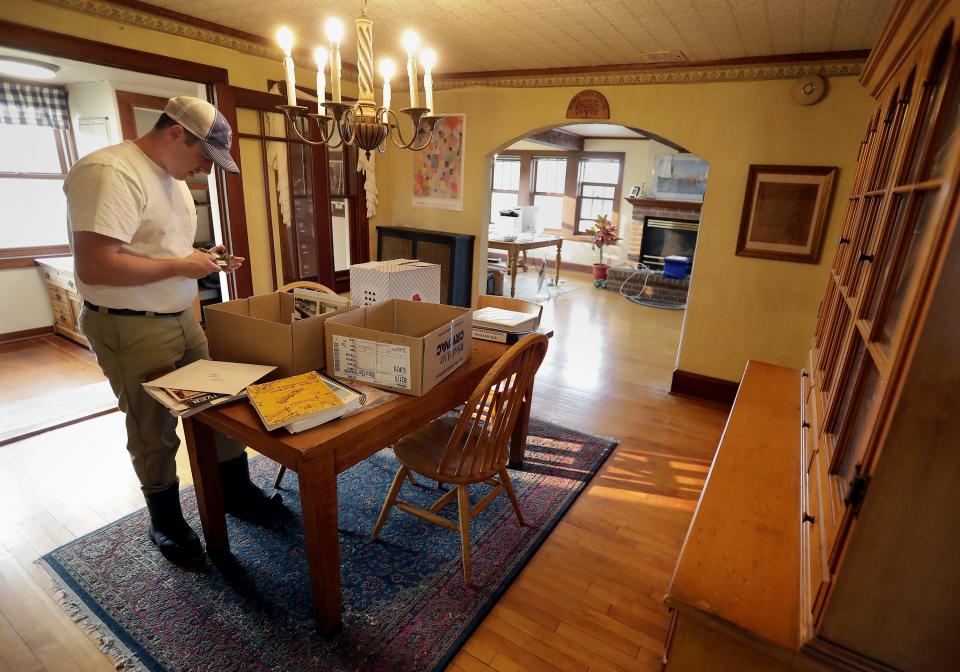 Jon Metzig looks through a box of family photos in what used to be his family's living room that now serves as office space on the second floor of Union Star Cheese Factory.