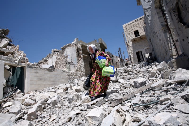 FOTO DE ARCHIVO: Una mujer libanesa camina entre los escombros de la ciudad de Bent Jbail, al sur del Líbano