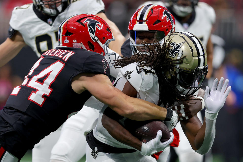 ATLANTA, GEORGIA - SEPTEMBER 29: Alvin Kamara (41) of the New Orleans Saints is tackled by Troy Andersen (44) and Lorenzo Carter (0) of the Atlanta Falcons during the first quarter at Mercedes-Benz Stadium on September 29, 2024 in Atlanta, Georgia. (Photo by Kevin C. Cox/Getty Images)