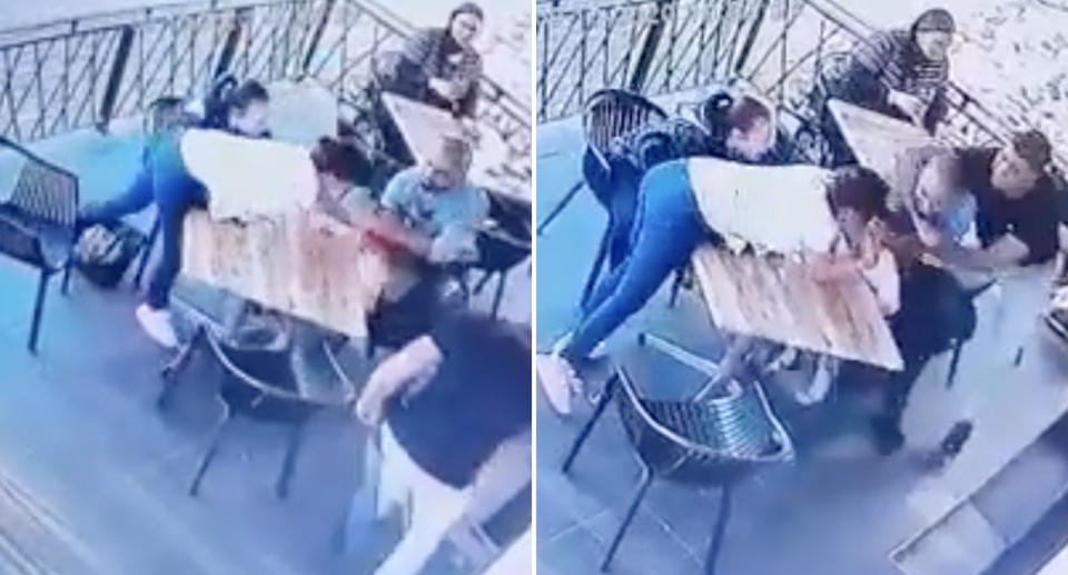 A man runs to a restaurant table and grabs a little girl. People try to stop him.