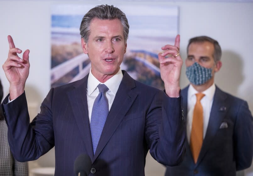 Los Angeles, CA - September 29: Los Angeles Mayor Eric Garcetti, right, listens to Gov. Gavin Newsom speak before he signed legislation that supports the state's work to expand mental health services and behavioral health housing as part of a comprehensive approach tackling the homelessness crisis at Alvarado Care Home in Los Angeles on Wednesday, Sept. 29, 2021. (Allen J. Schaben / Los Angeles Times)