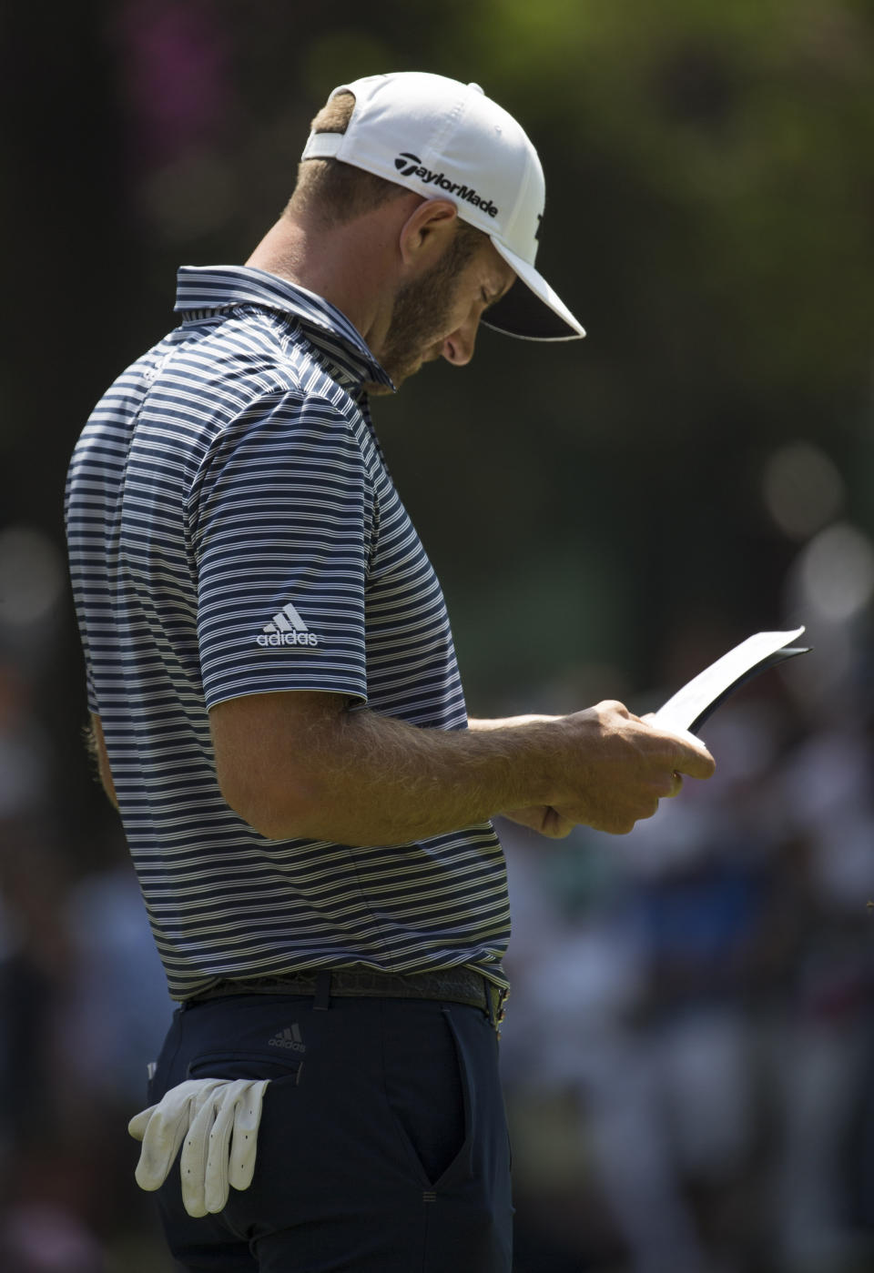 U.S golfer Dustin Johnson looks at his notes at the first hole during the WGC-Mexico Championship at the Chapultepec Golf Club in Mexico City, Sunday, Feb. 24, 2019. (AP Photo/Christian Palma)