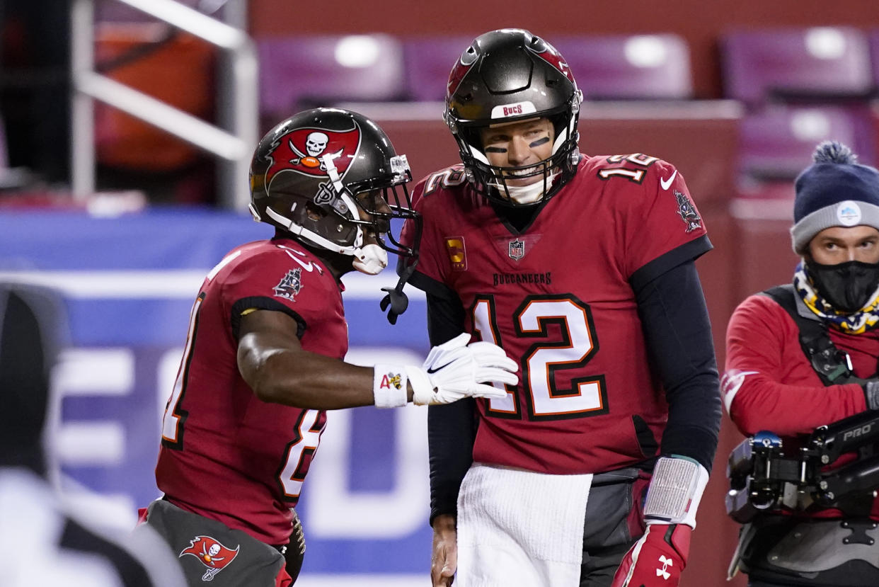 Tampa Bay Buccaneers wide receiver Antonio Brown (81) celebrates his touchdown with quarterback Tom Brady (12) during the first half of an NFL wild-card playoff football game against the Washington Football Team, Saturday, Jan. 9, 2021, in Landover, Md. (AP Photo/Andrew Harnik)