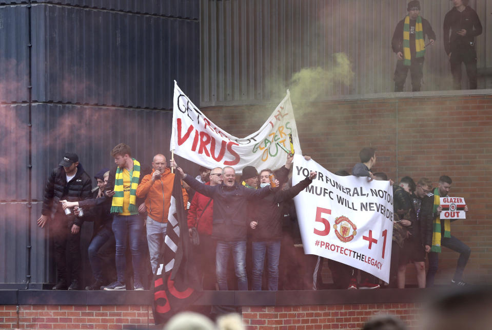 Fans hold up banners as they protest against the Glazer family, owners of Manchester United, before their Premier League match against Liverpool at Old Trafford, Manchester, England, Sunday, May 2, 2021. (Barrington Coombs/PA via AP)