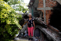 <p>Cenobia Riquelme, 76, a housewife who suffers from Alzheimer’s, poses for a portrait next to her house after an earthquake in Jojutla de Juarez, Mexico, September 29, 2017. Riquelme’s house was very badly damaged and her husband was killed. She and her husband were crushed by the rubble. Her husband could not be rescued, but Cenobia was rescued by a soldier. She is living in the backyard and could return to home once it’s rebuilt. Her son Sebastian (not pictured) said: “My mother searches for my father to make his lunch. This is all very sad and I am worried.” (Photo: Edgard Garrido/Reuters) </p>