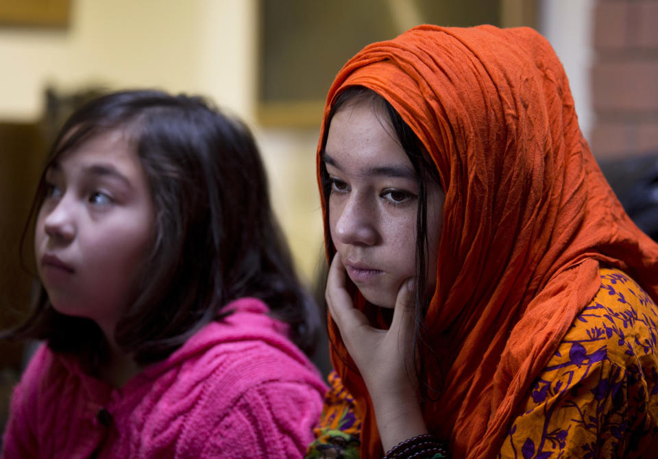 In this Nov. 29, 2018 photo, Shahnaz, 16, right, and Shakeela, 12, daughters of Mir Aman, speak to The Associated Press, in Islamabad, Pakistan. Scores of Pakistani men like Aman, whose Muslim Uighur wives have disappeared into internment camps in China, feel helpless, fighting a wall of silence as they struggle to reunite their families. Political and economic factors, including concerns about losing out on vast Chinese investments, have kept Muslim countries like Pakistan quiet about the plight of their fellow Muslims, being weaned off their faith in so-called re-education camps. (AP Photo/B.K. Bangash)