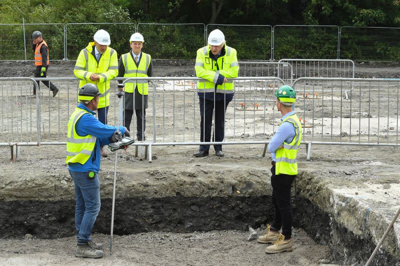 Britain's Prime Minister Boris Johnson speaks with workers as he visits the Speller Metcalfe's building site in Dudley