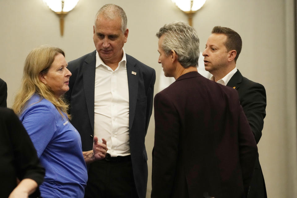 U.S. Congressmen Rep. Jared Moskowitz (D-FL), right, Mario Diaz-Ballart (R-FL), center, and Max Schachter, listen to Debbi Hixon before the start of a roundtable discussion, Friday, Aug. 4, 2023, in Parkland, Fla. The group toured the blood-stained and bullet-pocked halls, shortly before ballistics technicians reenact the massacre that left 14 students and three staff members dead in 2018. Schachter lost his son and Hixon lost her husband in the massacre. (AP Photo/Marta Lavandier)