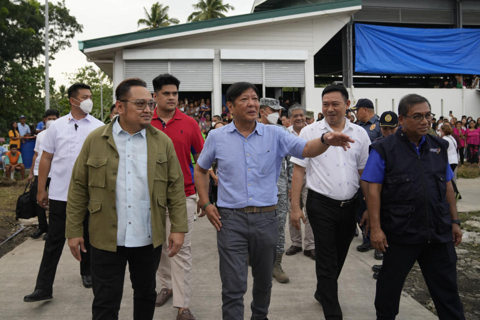 Philippine President Ferdinand Marcos Jr., center, visits an evacuation center in Guinobatan town, Albay province, northeastern Philippines, Wednesday, June 14, 2023. A gentle eruption of the Philippines' most active volcano that has forced nearly 18,000 people to flee to emergency shelters could last for months and create a protracted crisis, officials said Wednesday. (AP Photo/Aaron Favila)