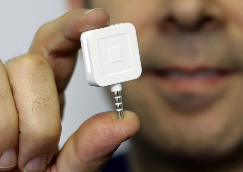 FILE - In this Jan. 5, 2015 file photo, Dr. Greg Werner poses for a picture with his Square credit card reader at his office in New York.  Visa has purchased a major stake in Square, the mobile payments services company headed by Jack Dorsey. Shares of Square jumped more than 32 percent in Friday, Feb. 12, 2016 premarket trading. (AP Photo/Seth Wenig, File)