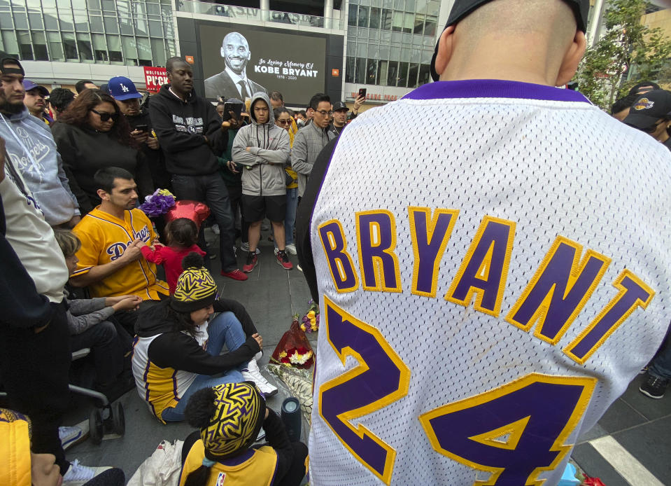 Fans mourn the loss of Kobe Bryant with makeshift memorials in front of La Live across from Staples Center, home of the Los Angeles Lakers in Los Angeles on Sunday, Jan, 26, 2020. Bryant, the 18-time NBA All-Star who won five championships and became one of the greatest basketball players of his generation during a 20-year career with the Los Angeles Lakers, died in a helicopter crash Sunday. (Keith Birmingham/The Orange County Register via AP)