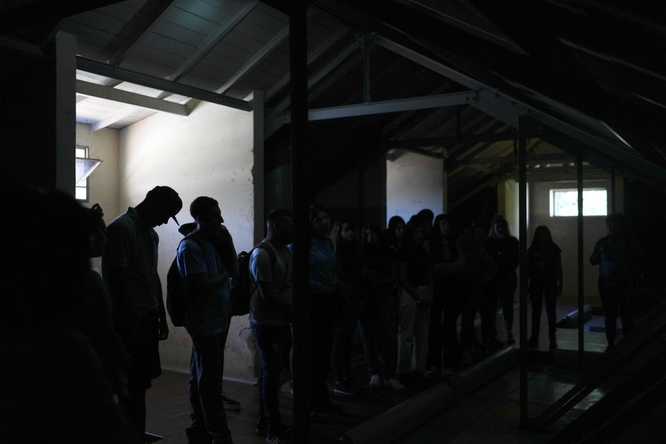 Students visit an area known as a "capucha," the Spanish word for hood, at the former Navy School of Mechanics, or ESMA, now a human rights museum, in Buenos Aires, Argentina, Friday, March 22, 2024. During the military dictatorship ESMA housed an illegal detention center, a place where detainees were hooded and believed to be tortured. (AP Photo/Natacha Pisarenko)