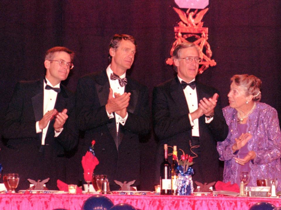 Jim Walton, John Walton, Rob Walton, and Helen Walton clapping at a banquet