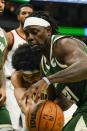 Cleveland Cavaliers' Jarrett Allen and Milwaukee Bucks' Jrue Holiday go after a loose ball during the first half of an NBA basketball game Monday, Dec. 6, 2021, in Milwaukee. (AP Photo/Morry Gash)