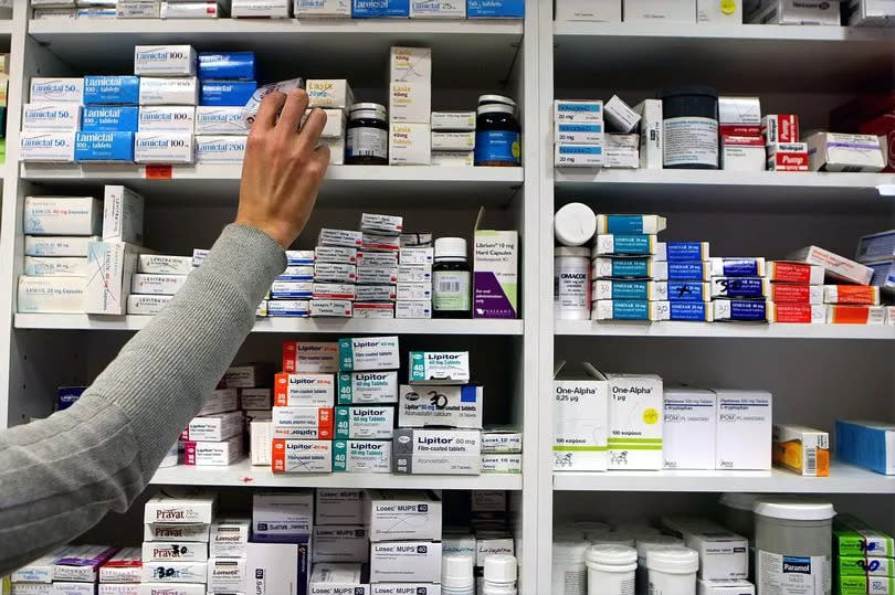 A pharmacist stocks shelves at a chemist