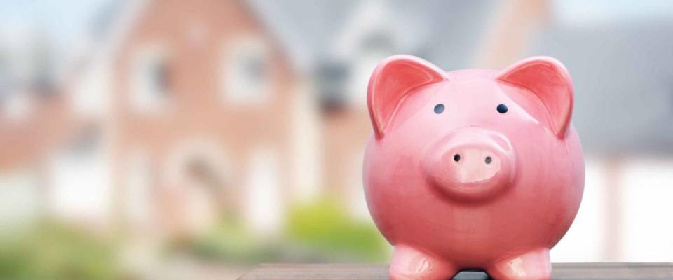 Saving to buy a house, real estate or home savings, piggy bank in front of property