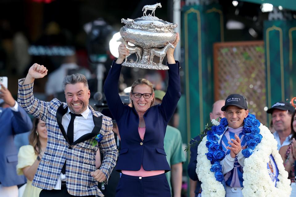 Arcangelo trainer Jena Antonucci (center) hoists the trophy with owner Jon Ebbert (left) and jockey Javier Castellano after winning the Belmont Stakes at Belmont Park. Antonucci is the first female trainer to win the race.