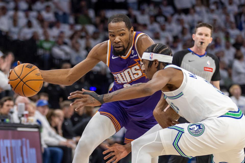 Phoenix Suns forward Kevin Durant (35) dribbles the ball around Minnesota Timberwolves forward Jaden McDaniels (3)] in the first half during game one of the first round for the 2024 NBA playoffs at Target Center.
