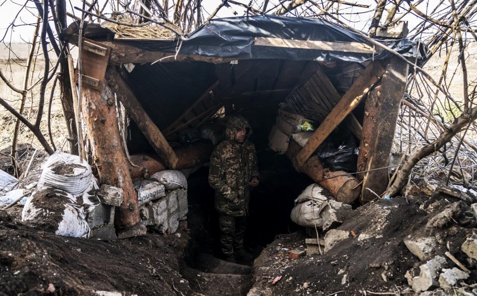 Ukrainian soldiers wait in their fighting position for the commander's order