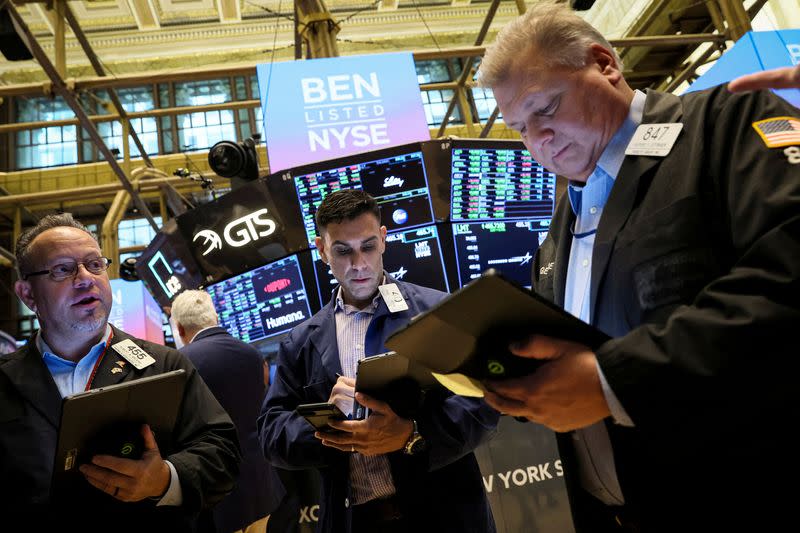 FILE PHOTO: Traders work on the floor of the NYSE in New York