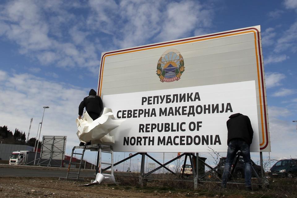 Workers install a new road sign reads Republic of North Macedonia in the southern border with Greece, near Gevgelija, Wednesday, Feb. 13, 2019. Workers in the newly renamed North Macedonia have begun replacing road signs to reflect the change in their country's name, following a deal with neighboring Greece to end a nearly three decade-long dispute and secure NATO membership. (AP Photo/Boris Grdanoski)