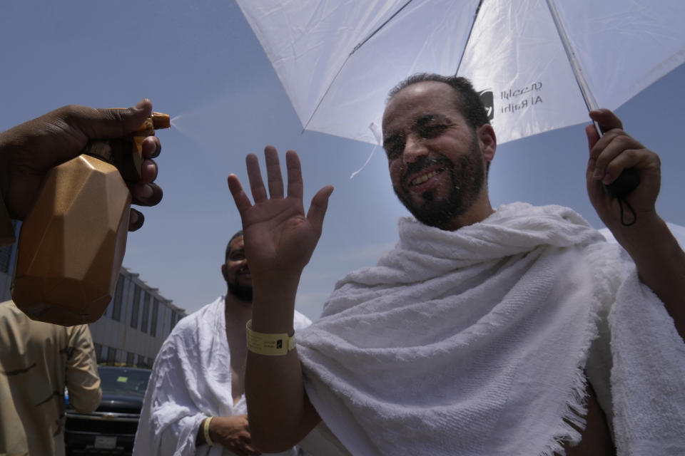 A police officer sprays cold water at a Muslim pilgrim at the Mina tent camp in Mecca, Saudi Arabia, during the annual Hajj pilgrimage, Monday, June 26, 2023. Muslim pilgrims are converging on Saudi Arabia's holy city of Mecca for the largest Hajj since the coronavirus pandemic severely curtailed access to one of Islam's five pillars. (AP Photo/Amr Nabil)