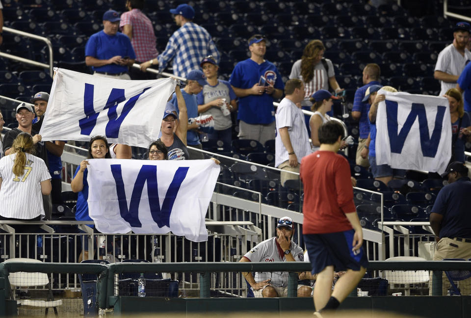 Chicago Cubs fans wave flags after a baseball game between the Washington Nationals and the Chicago Cubs, Thursday, Sept. 6, 2018, in Washington. The Cubs won 6-4 in 10 innings. (AP Photo/Nick Wass)