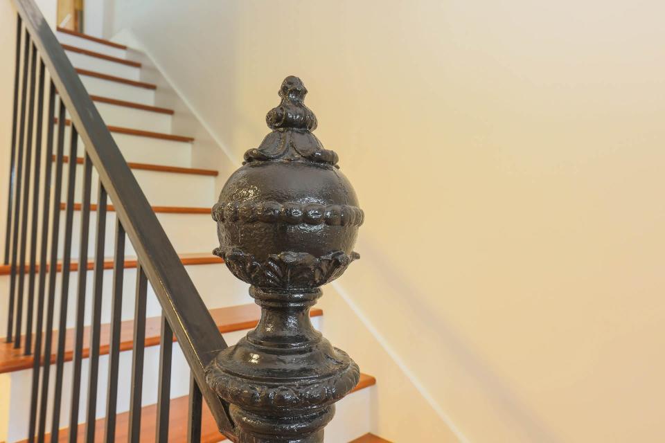 A decorative post that was originally outside has been restored and added to the staircase in the garden level space.