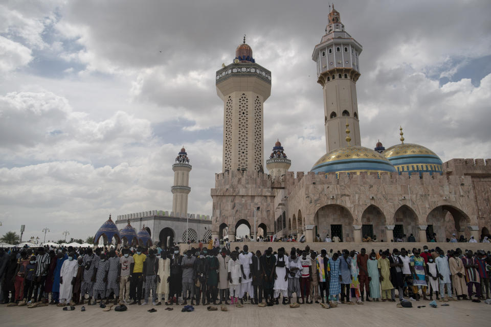Wearing protective face masks, pilgrims from the Mouride Brotherhood pray outside the Grand Mosque of Touba during the celebrations of the Grand Magal of Touba, Senegal, Tuesday, Oct. 6, 2020. Despite the coronavirus pandemic, thousands of people from the Mouride Brotherhood, an order of Sufi Islam, gather for the annual religious pilgrimage to celebrate the life and teachings of Cheikh Amadou Bamba, the founder of the brotherhood. (AP Photo/Leo Correa)