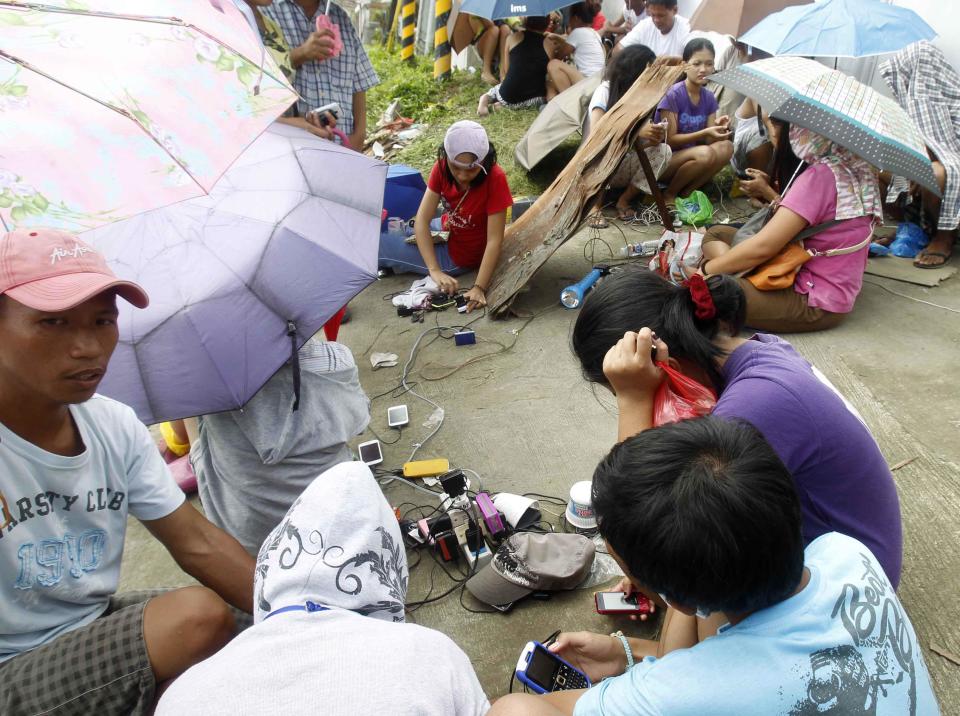 Residents share a power outlet to charge their mobile phones after super typhoon Haiyan hit Tacloban city, central Philippines November 11, 2013.