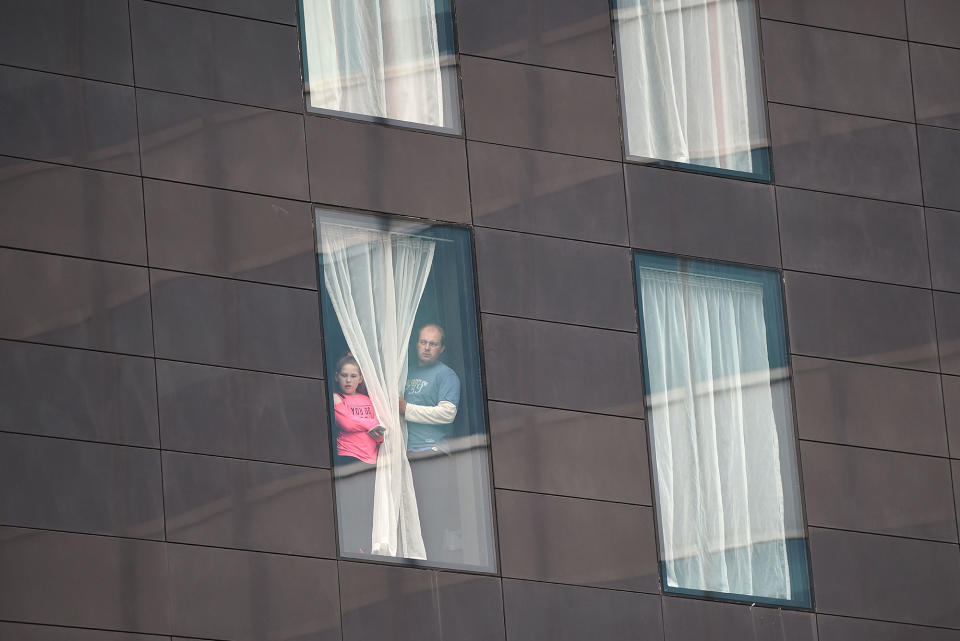 <p>People affected by the deadly terror attack at Manchester Arena look out from a hotel window in Manchester, northwest England on May 23, 2017. (Oli Scarff/AFP/Getty Images) </p>