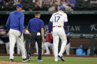 Texas Rangers starting pitcher Nathan Eovaldi (17) walks off the field with pitching coach Mike Maddux, left, and head athletic trainer Matt Lucero, center, during the sixth inning of a baseball game against the Washington Nationals in Arlington, Texas, Thursday, May 2, 2024. Eovaldi left the game with an unknown injury. (AP Photo/Tony Gutierrez)