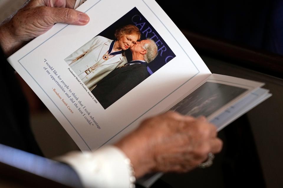 A guest looks at the program before a tribute service for former first lady Rosalynn Carter in Atlanta on Nov. 28, 2023. Funeral services are scheduled for the next day in Plains, Ga., at the church where former President Jimmy Carter taught Sunday school. She is set to be buried in a private ceremony at their home.