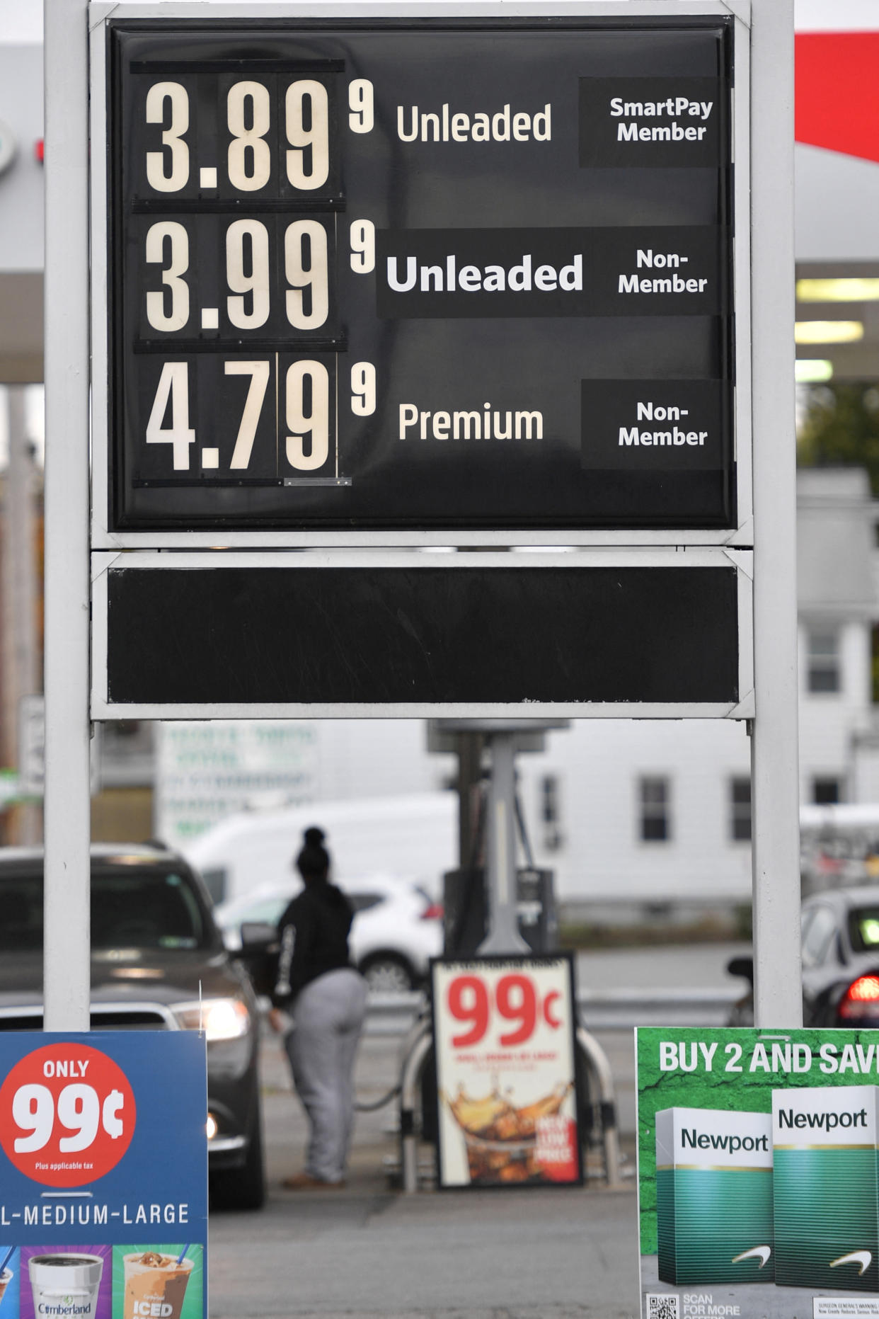A women pumps gasoline under a placard with fuel costs at a gas station in Wilkes-Barre, Pennsylvania, U.S. October 19, 2022.  REUTERS/Aimee Dilger