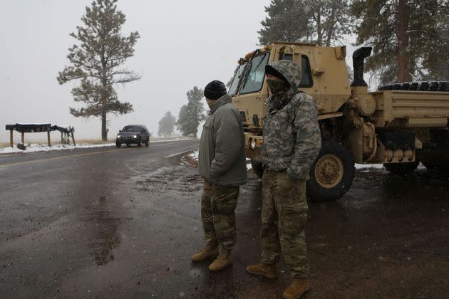 <p>Les membres de la Garde nationale du Colorado surveillent un barrage routier menant à l'incendie de Cameron Peak alors que la neige tombe un jour après que la région a subi des records de chaleur.</p>